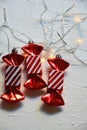 Christmas flat lay scene with three red and white striped candy ornaments plus white lights Royalty Free Stock Photo