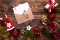 Christmas flat lay on a wooden background with keys to new house in the center with a envelope with a note sheet. New year, transf