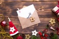 Christmas flat lay on a wooden background with keys to new house in the center with a envelope with a note sheet. New year,