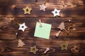 Christmas flat lay of wooden stars, fir trees and clothespins on a dark background with a square sheet for notes in the center. Ne