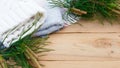 Christmas flatlay on a rustic wooden background: green pine needles with cones, warm woolen things in white and blue. New year`s c Royalty Free Stock Photo