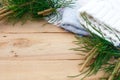 Christmas flatlay on a rustic wooden background: green pine needles with cones, warm woolen things in white and blue. New year`s c Royalty Free Stock Photo