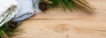 Christmas flatlay on a rustic wooden background: green pine needles with cones, warm woolen things in white and blue. New year`s c Royalty Free Stock Photo