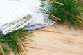 Christmas flatlay on a rustic wooden background: green pine needles with cones, warm woolen things in white and blue. New year`s Royalty Free Stock Photo
