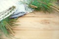 Christmas flatlay on a rustic wooden background: green pine needles with cones, warm woolen things in white and blue. New year`s Royalty Free Stock Photo