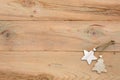 Christmas flatlay on a wooden background in rustic style: decorations made of wood in the shape of a star, spruce. Royalty Free Stock Photo