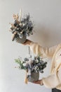 Christmas floral composition of Christmas tree branches and candles for a gift in the hands of a woman. New Year`s decor for the Royalty Free Stock Photo