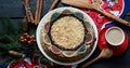 Christmas food background in rustic style. Homemade round layered honey cake on a bright napkin on a dark background with space