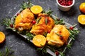 Christmas food. Chicken meat baked with cranberries, tangerines and rosemary on stone background