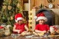 Christmas food and drink. Little boy and cute little girl with santa hat preparing cookies in the kitchen at home. Happy Royalty Free Stock Photo