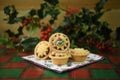 Christmas food photography picture with pastry fruit mince pies and fresh cut holly leaves and berries on green red kitchen table