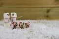 Christmas food photography using marshmallows shaped as snowman with iced on smile and standing in snow with Santa Claus ornaments Royalty Free Stock Photo