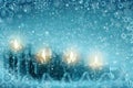 Four burning Advent candles and snowfall. Christmas background.