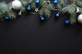 Christmas frame border with blue and sliver modern decorations, baubles, fir tree branches on dark black background. Elegant Royalty Free Stock Photo