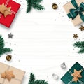 Christmas frame border composition. Gift box, pine tree, Christmas balls, star, and confetti isolated on white wooden background. Royalty Free Stock Photo