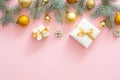 Christmas frame border with fir tree branches, Christmas golden balls, presents on pastel pink background. Flat lay, top view Royalty Free Stock Photo