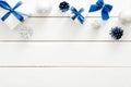 Christmas frame border made of blue and silver decorations, balls, gift boxes, cones on white wooden background. Flat lay, top Royalty Free Stock Photo