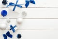 Christmas frame border made of blue and silver decorations, balls, gift boxes, cones on white wooden background. Flat lay, top Royalty Free Stock Photo