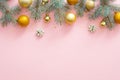 Christmas frame border made of fir tree branches, golden balls, confetti on pastel pink background. Flat lay, top view, copy space Royalty Free Stock Photo