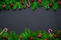 Christmas frame border wirh fir branch, candy cane and baubles on black background