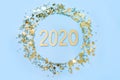 Christmas frame with date New 2020 Year and golden confetti stars on blue. Flat lay. View from above. Xmas vertical border Royalty Free Stock Photo
