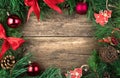 Christmas frame decorated with red Christmas toys, bows and glass balls pine branch on a natural wooden background. Royalty Free Stock Photo