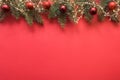 Christmas frame with evergreen branches, garland, red balls, gift on red Royalty Free Stock Photo