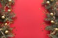 Christmas frame with fir branches, golden balls, garland on red background. Space for text, view from above, flat lay. Happy New Royalty Free Stock Photo