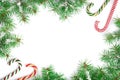 Christmas Frame of Fir tree branch with candy canes and snow isolated on white background with copy space for your text Royalty Free Stock Photo