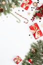 Christmas frame flat lay with pine, red presents, golden elements, candy canes, confetti. Christmas template on white Royalty Free Stock Photo