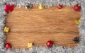 Christmas frame with gift box, bells, christmas balls, pinecones and bow over wooden table with copy space