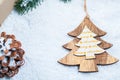 Christmas frame with gift, the branches of the Christmas tree and wooden decorations on snow background. Royalty Free Stock Photo