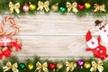 Christmas frame made of fir branches decorated with balls, bows, candy canes and boxes on a light wooden background Royalty Free Stock Photo