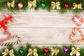 Christmas frame made of fir branches decorated with balls, bows, candy canes and boxes on a light wooden background Royalty Free Stock Photo