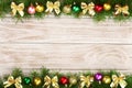 Christmas frame made of fir branches decorated with balls and bows on a light wooden background Royalty Free Stock Photo