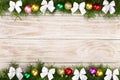 Christmas frame made of fir branches decorated with balls and bows on a light wooden background Royalty Free Stock Photo