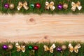 Christmas frame made of fir branches decorated with golden bows and balls on a light wooden background Royalty Free Stock Photo
