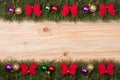 Christmas frame made of fir branches decorated with red bows and balls on a light wooden background Royalty Free Stock Photo