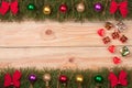 Christmas frame made of fir branches decorated with red bows and balls on a light wooden background Royalty Free Stock Photo