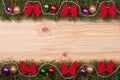 Christmas frame made of fir branches decorated with red bows beads and balls on a light wooden background Royalty Free Stock Photo
