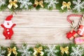 Christmas frame made of fir branches decorated with snowflakes and bows on a light wooden background Royalty Free Stock Photo