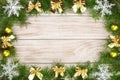 Christmas frame made of fir branches decorated with snowflakes and gold bows on a light wooden background Royalty Free Stock Photo