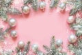 Christmas frame made of fir branches, snowy white decorations,white balls on pink table. Xmas background. Flat lay. Top Royalty Free Stock Photo