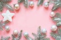 Christmas frame made of fir branches, snowy white decorations,white star balls on pink table. Xmas background. Flat lay. Top view Royalty Free Stock Photo