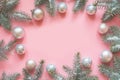 Christmas frame made of fir branches, white balls on pink. Xmas. Flat lay. Top view with copy space Royalty Free Stock Photo