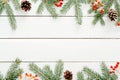 Christmas frame made of fir tree branches, red berries, pine cones on rustic wooden white background. Christmas, New Year, winter Royalty Free Stock Photo