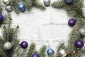 Christmas frame made of fir, Christmas tree decorations in silver and blue on a light brick background. Copy space. Flat lay Royalty Free Stock Photo