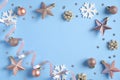 Christmas frame made of gold rose color decorations, stars, balls, snowflakes, garland, confetti on blue background. Xmas, winter Royalty Free Stock Photo