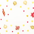 Christmas frame made of golden and red decorations with confetti on white background. Flat lay Royalty Free Stock Photo