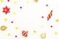 Christmas frame made of golden and red decorations with confetti on white background. Flat lay, top view, copy space Royalty Free Stock Photo